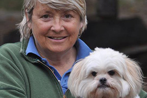 Senior Tanamakoon staff member Patti Thom poses with a white dog