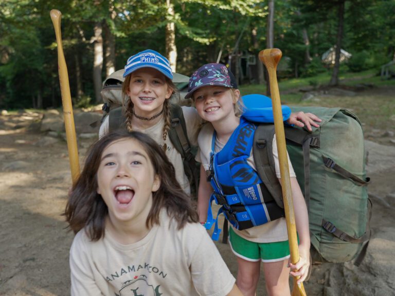Three girls pose exuberantly for the camera