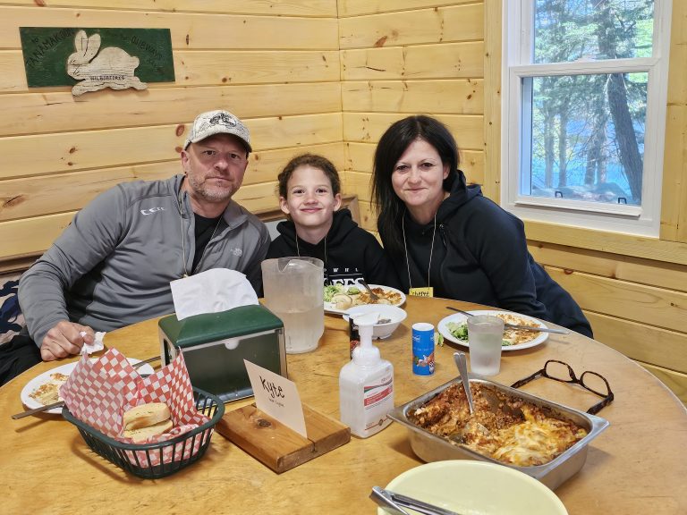 Two adults and a child around a table laden with food