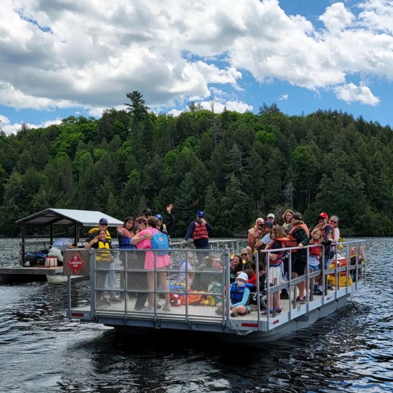 A large group of people on a pontoon boat on a lake