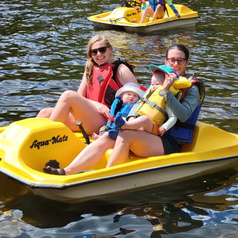Two people and a child in a yellow peddle boat