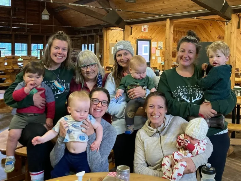 Six women and five young children huddle together for a photo