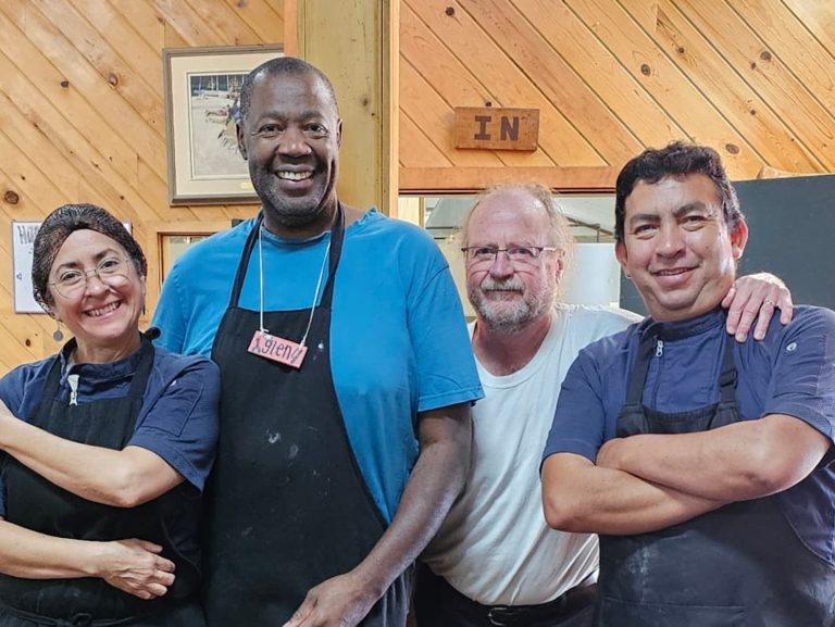 People in aprons and hairnets pose for a photo