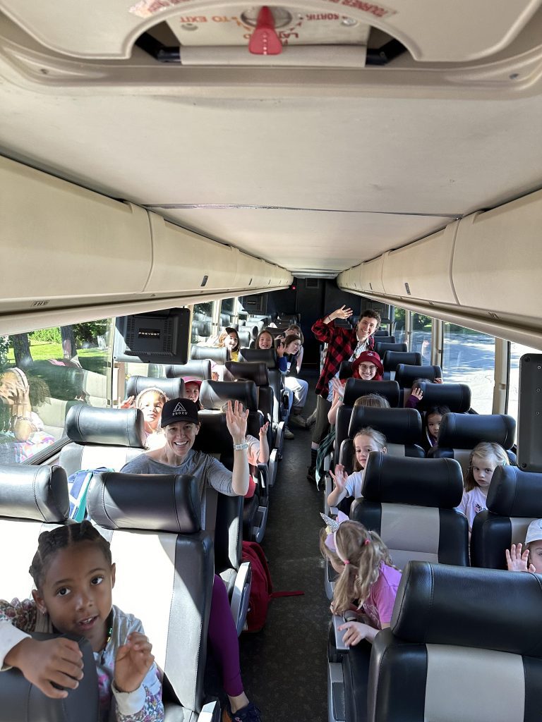 A group of children on a coach bus, seen from the front of the bus