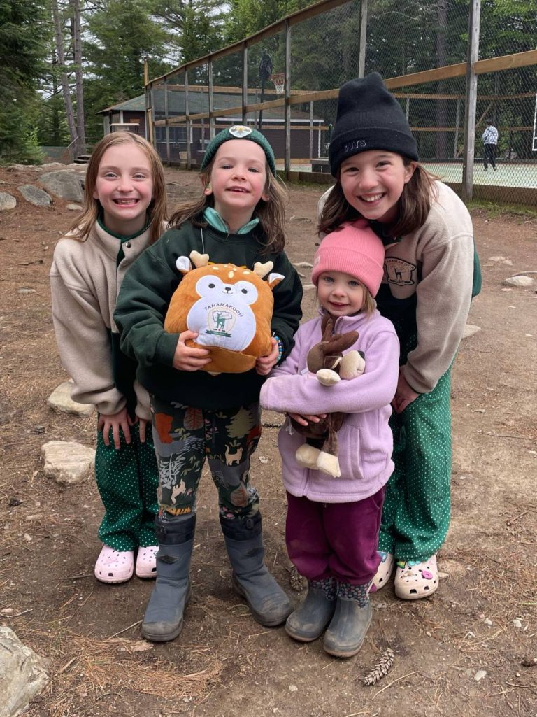 A group of four children, two of them squeezing stuffies